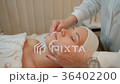 Experienced cosmetologist cleanses face of client Experienced cosmetologist cleanses face of client 36402200