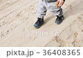 A little boy is walking along the sand 36408365