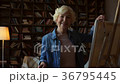 Nice senior woman standing near easel 36795445