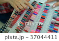 Female client chooses a color from a large palette Female client chooses a color from a large palette 37044411