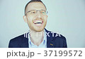 A young man in glasses looks at the camera and 37199572
