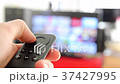 Watching Smart TV And Using Modern Black Remote Co 37427995