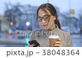 Young female drinking coffee and browsing in her 38048364