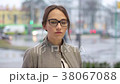 Female teenager wearing glasses seriously looks at 38067088