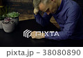 Depressed man seated at a table 38080890