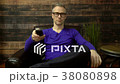 Man sits watching TV and changes channel 38080898