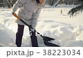 Young woman removes snow by shovel in suburbs in 38223034