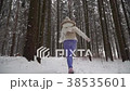 A girl is running in the winter forest. 38535601