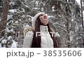 A girl is enjoying a snowfall in the winter forest 38535606