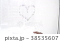 Hand draws love heart on cold fogged window  38535607