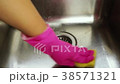 Female hand in rubber glove cleaning metallic sink 38571321