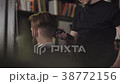 Barber cuts the hair of the client with trimmer 38772156