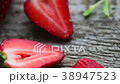 Halves of ripe strawberry over rustic old board.  38947523