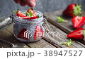 Hand is sprinkling coconut chips on chia pudding 38947527