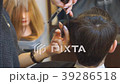 Man getting a haircut by a hairdresser. 39286518