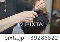 Man getting a haircut by a hairdresser. 39286522