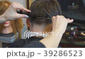 Man getting a haircut by a hairdresser. 39286523