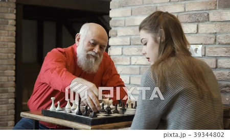 Young girl play chess with her grandpaの動画素材