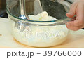 The cook is beating the cheese with a blender. 39766000