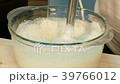 The cook whips the curd mass with a blender. 39766012
