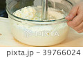 The cook whip the milk with a blender. 39766024