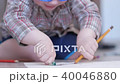Cute boy in funny glasses draws with both hands on paper at home 40046880