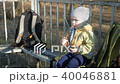 A pretty boy is eating a sausage outside. Cooked on fire bbq 40046881