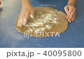 Woman flouring and rolling the dough with rolling pin, top view FullHD color graded 40095800