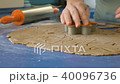 Woman cuts gingerbread man cookies in dough with cutter, closeup FullHD color graded 40096736