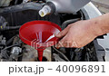 Mechanic pouring fresh oil to car engine 40096891