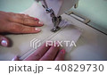 middle-aged woman hand stitching on beige fabric sewing machine 40829730
