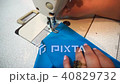 middle-aged woman hand stitching on blue fabric sewing machine 40829732