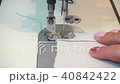 middle-aged woman hand stitching on beige fabric sewing machine 40842422