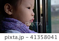 Little girl feeling sad while looking out of train 41358041