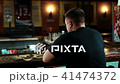 Young man receives glass of beer at table in night bar. 41474372