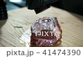 Young cook sprinkles beef steak with pepper on table in kitchen. 41474390