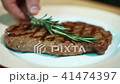 Beef steak is being decorated with green rosemary in expensive restaurant, close up. 41474397