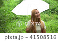 Woman walking hand holding white umbrella under ra 41508516