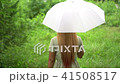 Woman walking hand holding white umbrella under ra 41508517