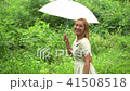 Woman walking hand holding white umbrella under ra 41508518