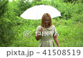 Woman walking hand holding white umbrella under ra 41508519