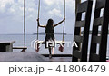 beautiful girl is riding on a swing against the sea in a cafe on the pier. 41806479