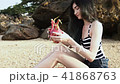 long-haired girl on the beach demonstrates the flesh of the dragon fruit exotic. 41868763