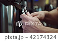 In gym in training car man fastens handle on a sturdy carbine. 42174324