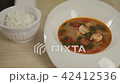 Tom yum serve in white bowl and rice serve on dish 42412536