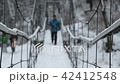 Man walking along the bridge over the winter river 42412548