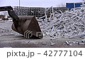 A bulldozer tractor moves waste from the production of plastic windows in a landfill 42777104