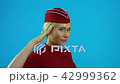 The stewardess salutes and smiles 42999362