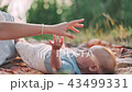 little baby lying on grass during summer sunny day and playing with mom 43499331