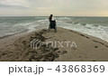 The disabled person gets out of the stroller on the shore of the sea 43868369